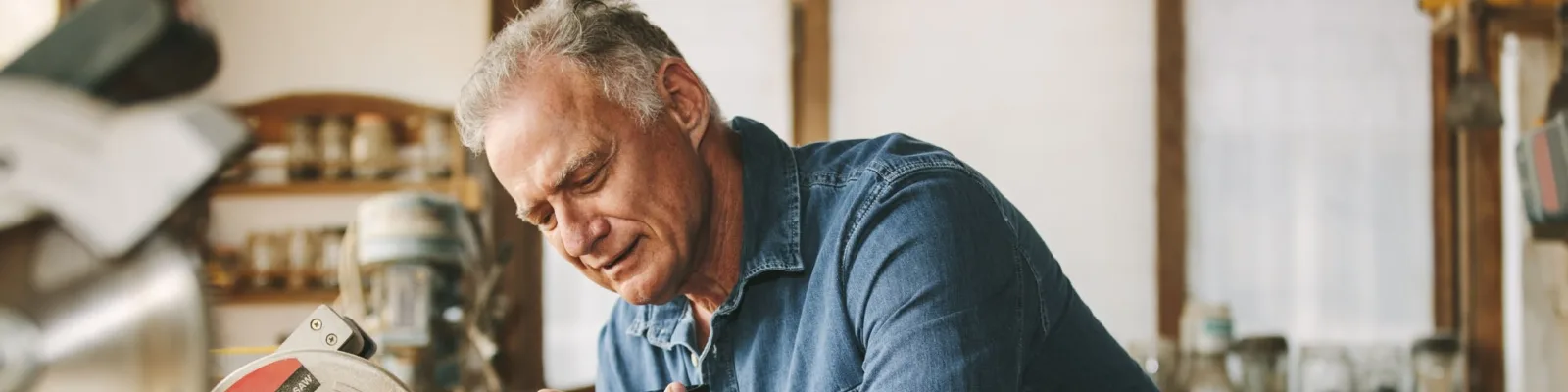 Older man working in shed talking on the phone